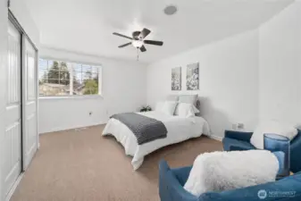 The spacious primary bedroom features a large window that brings in abundant natural light and overlooks the neighborhood. Neutral walls, plush carpet, and a ceiling fan create a bright and comfortable retreat.