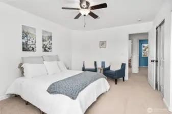 From this angle, the primary bedroom showcases its generous layout and easy access to the adjoining hallway. Double-door closets provide ample storage while maintaining a clean, streamlined look.