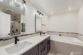 Main-floor primary suite bath with jetted tub, rain shower & heated towel rack