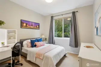 Main floor bedroom overlooking lush landscaping in backyard.
