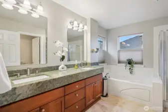 5-piece ensuite bath with custom raised slab stone counters and travertine tile floors.