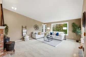 The inviting living room is filled with natural light and anchored by a cozy fireplace that makes the space feel instantly welcoming.