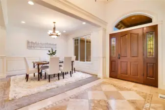 Formal dining room with detailed moulding and wainscoting.