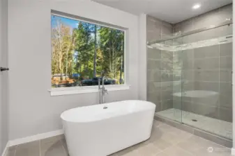 Freestanding soaking tub overlooks the private backyard. Large custom tiled walk in shower.