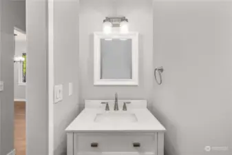 Powder Bath in hallway behind kitchen area allows for easy access for guests.