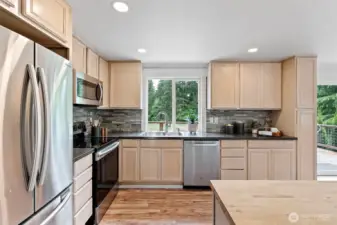 The kitchen includes an island with storage, SS appliances, and laminate flooring.  Enjoy your views from the kitchen window as you do dishes or prepare a meal.
