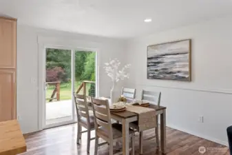 The dining room enjoys easy access to the expansive deck, perfect for barbecuing and enjoying the lovely acreage.