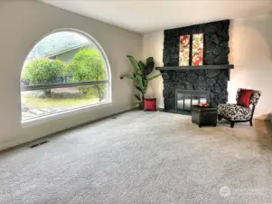 Large Palladian window and word burning fireplace in formal living room