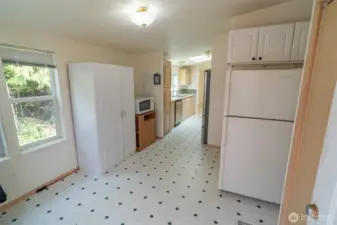 Behind the kitchen where the washer and dryer and an extra fridge/freezer.