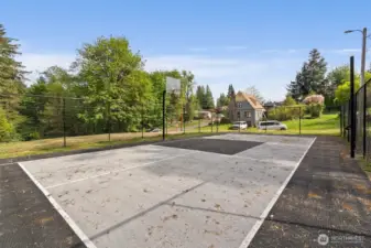 Tennis court, pickleball court, basketball court, all fenced.  Vacant lot beyond may have potential for development