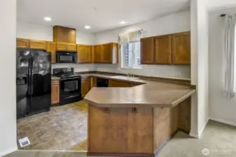 Peninsula counter with eating bar separates living space from Kitchen.