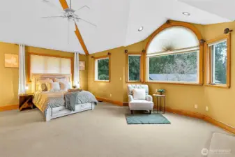 Large primary bedroom with tall ceilings.