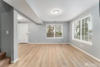 Main level living room looking towards front for and staircase to the upper level.