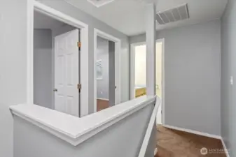 Upper level landing looking towards two bedrooms and a bathroom.