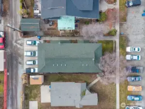 Bird's-eye view of 3 unit building, landscaped yard and parking.