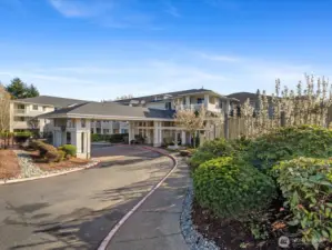 Exterior view of Le Chateau Condominiums with landscaped grounds, private drive, and covered entry in Bellevue’s Woodridge area.