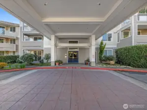 Covered building entrance with drive-up access for loading and unloading, located at the main lobby entry.