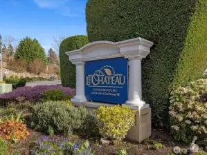 Le Chateau Condominium community signage with maintained landscaping and entry along 132nd Ave SE, located in Bellevue’s Woodridge area.