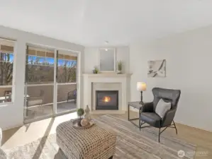 Living room with gas fireplace and direct access to covered deck, providing natural light and indoor-outdoor connection.