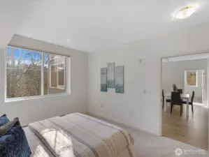 Bedroom with large window overlooking wooded surroundings and direct connection to main living areas. Layout supports separation between bedrooms and shared spaces.