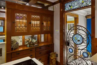 Sliding copper gate with glass details leads to full bathroom & pneumatic elevator off the kitchen.
