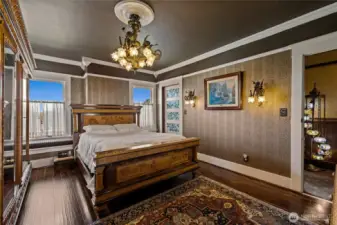 Striking bedroom on the second floor with hand cast chandelier & wall sconces.