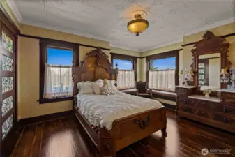 Bedroom #2 on the second floor with glass paneled door to bedroom #1.   Window seats offer great views of the neighbor hood as the home is perched on a high spot.