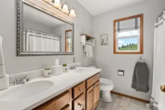 Recently remodeled hall full bath with double vanities, quartz countertops and lvp flooring.