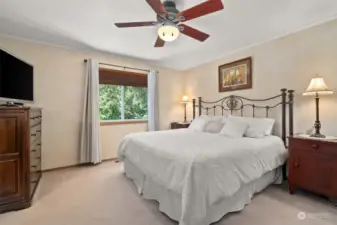 Nicely appointed primary bedroom with ceiling fan.