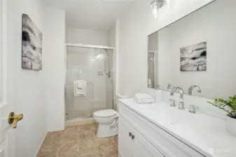 An updated 3/4 bathroom with tile shower, new flooring, new vanity and new toilet on the lower level, adjacent to the 5th bedroom.