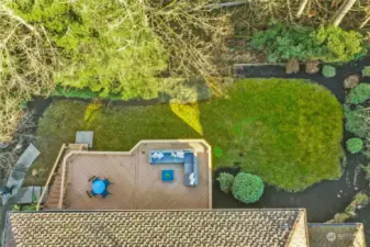 A staircase from the deck provides easy access to the patio and lush backyard below, enveloped with privacy and backing to green space.