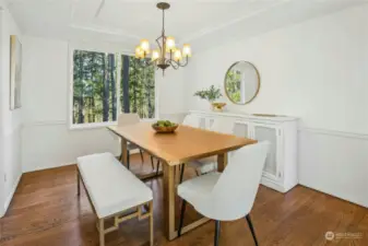 Custom details in the dining room include solid hardwood floors, wainscotting, a tray ceiling and crown mmolding.