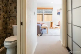 This view is from the hallway to the "primary suite" - this section of the house has a pocket door that can close off the bathroom with its heated floors and jetted tub, the big closet on the right, and the bedroom.