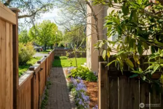 Along the south side of the house is a brick walkway and flower beds...continuing on into the front yard where there are several roses!