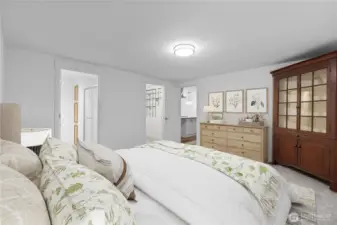 This angle shows the primary bedroom’s layout, with access to the ensuite area and ample wall space for dressers or additional furnishings. The staging helps buyers visualize the room’s scale and flow, emphasizing comfort and usability.