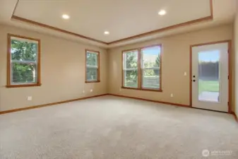Primary Bedroom with lcoffered ceilings, recessed lightingt and door to rear covered deck & backyard.