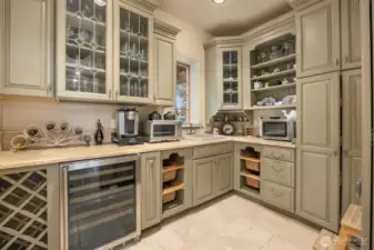 Splendid butler's pantry with extensive cabinetry and a granite sink. Room for it all.