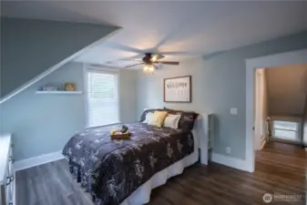 The primary bedroom is spacious with a skylight, built-in dresser, and ceiling fan.