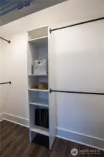 The primary bedroom has a unique closet with shelving and French doors.