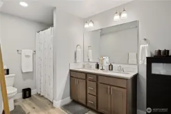 The primary suite with double sink vanity and easy walk-in shower.