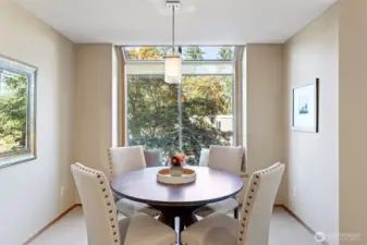 The dining area with lots of light, windows and an elegant ceiling fixture.