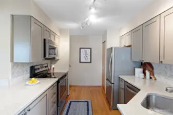The updated kitchen with quartz countertops, updated stainless appliances, shaker style cabinet doors and herringbone backsplash.