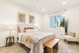 Large window and tall ceilings make this primary suite airy and inviting.