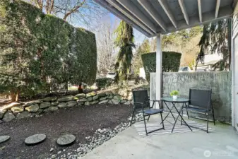 Covered, ground-level patio off living room further extends living space year-round