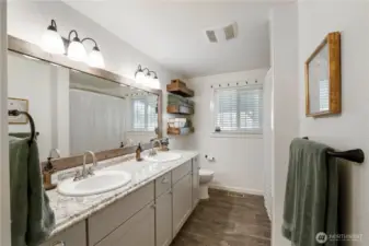 Large, bright main bathroom with double sinks, lots of countertop space with shower/ tub combo