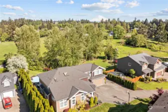 Check out this aerial view of this amazing home on just under an acre that backs to a green belt with lots of privacy and partial views of Mount Rainier!