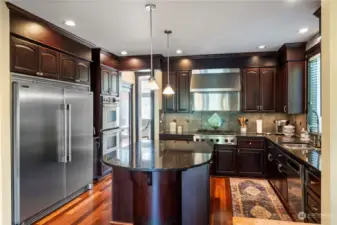 Third view of this stunning kitchen with commercial cook top and hood with lots of counter top space. Oil rubbed goose neck faucet and tile back splash await all your cooking needs.