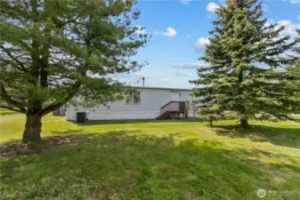 Singlewide is discretely placed behind tree area