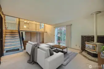 Lower level has gas burning fireplace, sliding glass door to backyard and storage cabinets with crawl space access.  *Photo is virtually staged.