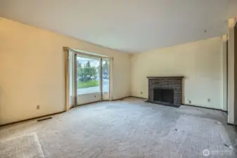 Large stepdown living room with wood burning fireplace and lots of natural light!